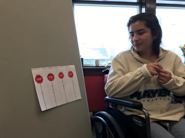 Student in wheelchair looks at data chart