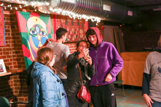 People share photos on phone screen in event space