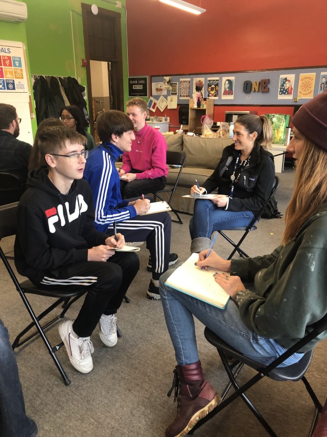 Students and adults drawing each other