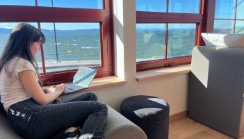 Student working quietly by a window overlooking the lake