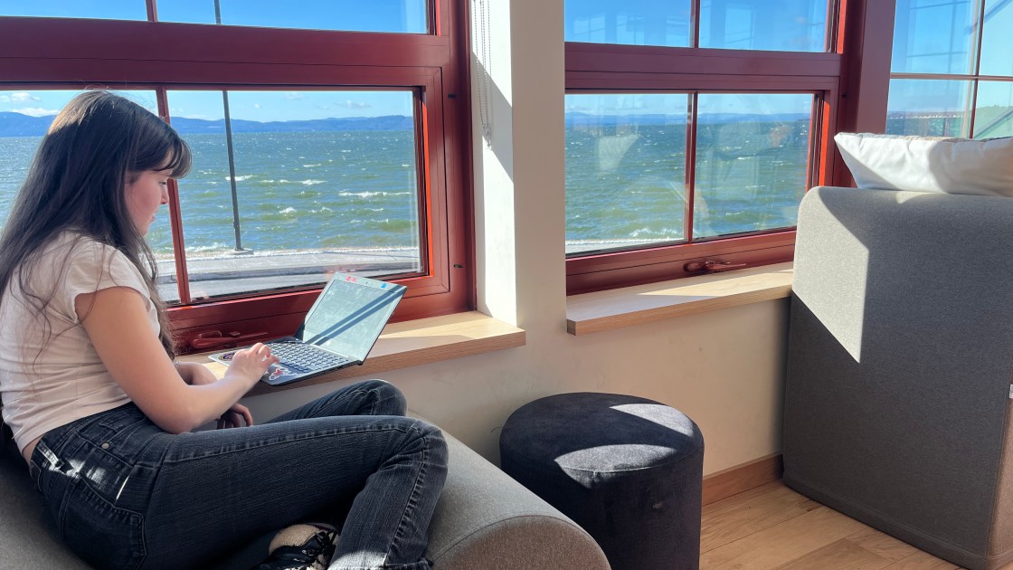 Student working quietly by a window overlooking the lake